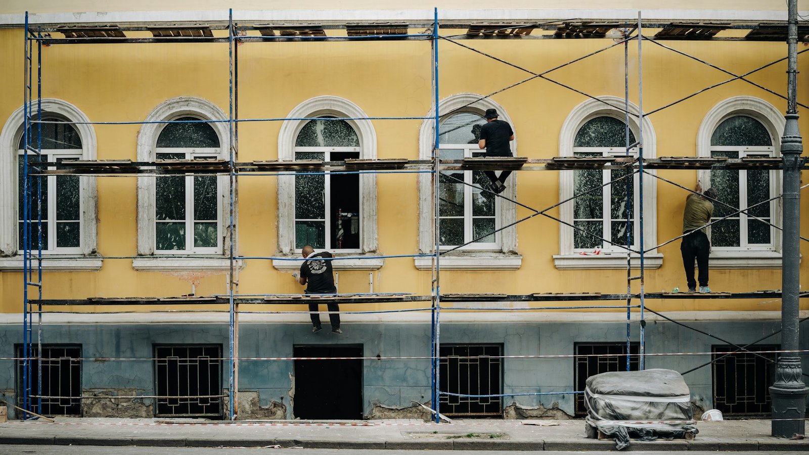 Workers on scaffolding carrying out building facade maintenance
