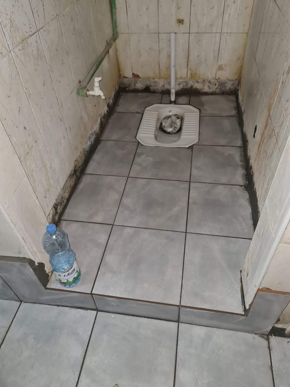 Bathroom toilet installation with tile flooring